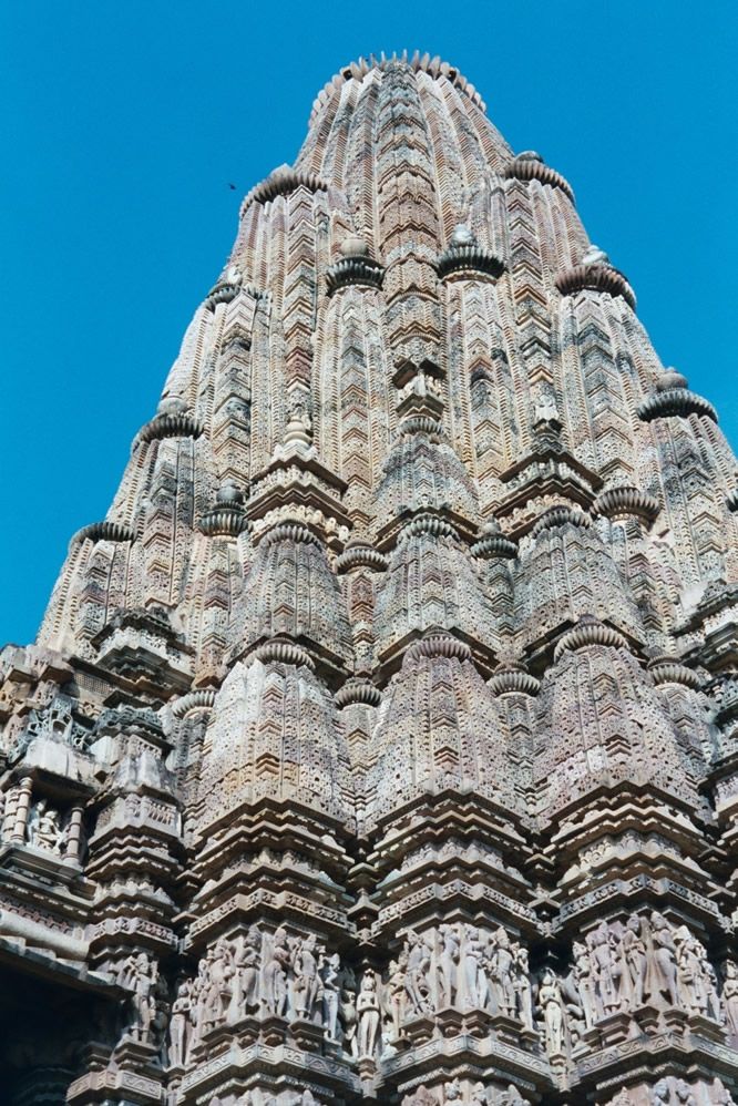 The shikara is covered with miniature shikaras known as kudus or candrashala; each represents the home of a god.