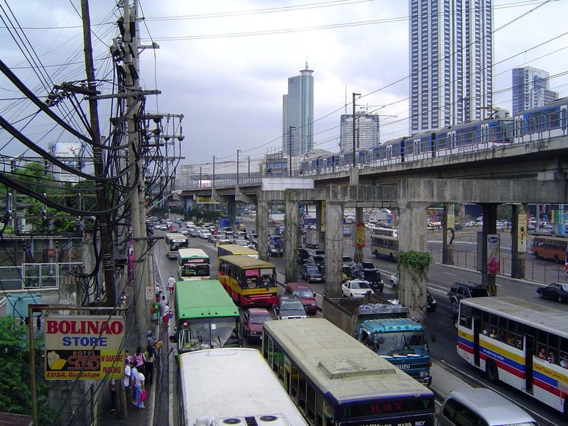 We've come north now a couple of miles to Ortigas Center. Metro Rail runs here over the city's circumferential beltway, a road built by Amer