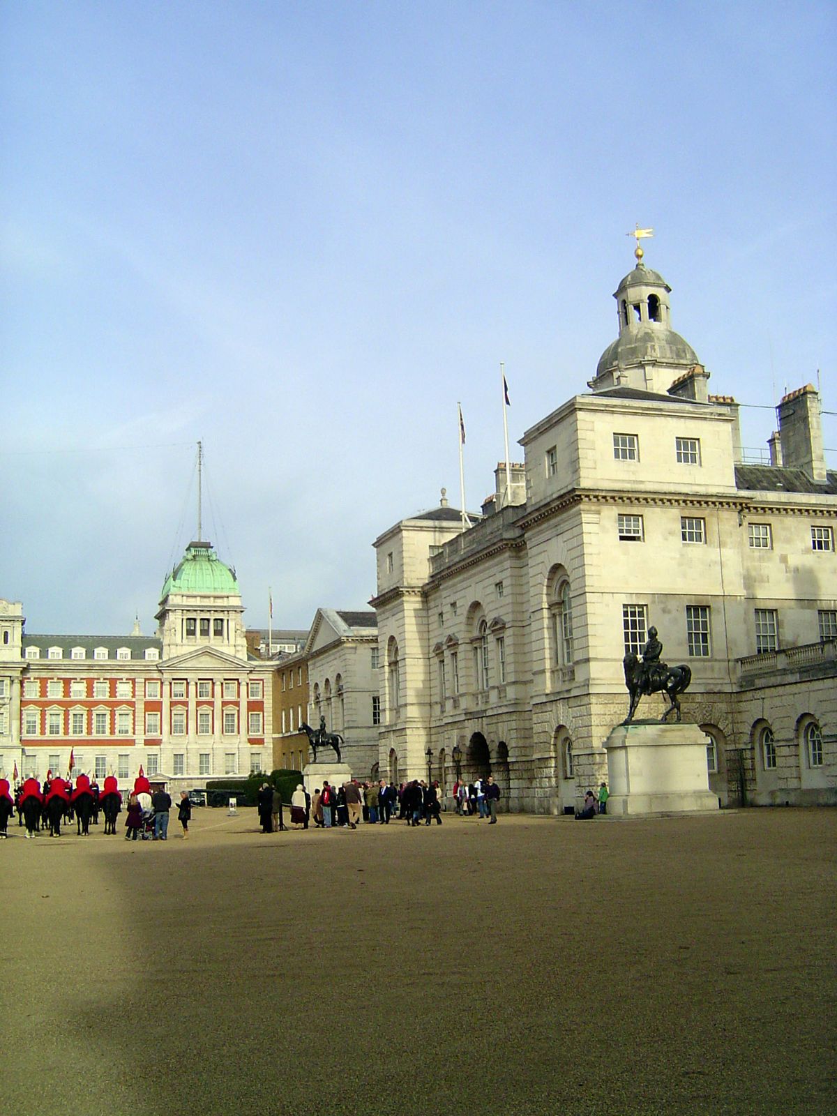 Two officers on plinths watch the Horse Guards Parade.