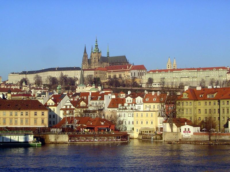 Across the river, St. Vitus Cathedral, within Prague Castle, rises in the morning light.