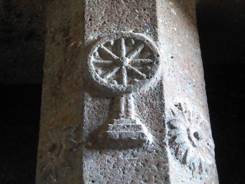 Ornaments including a dharmachakra are carved on the columns.
