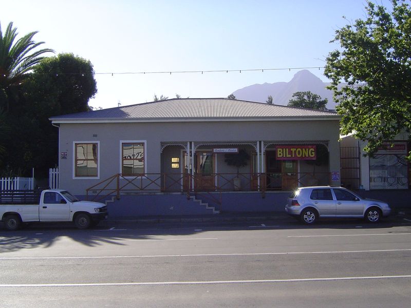 A house once, the gable was removed and the building divided into two businesses: dentist on the left, biltong shop on the right. The stuff 