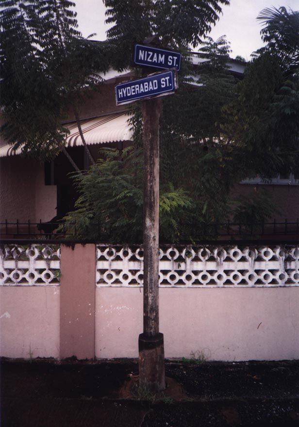 We begin again in Port-of-Spain, where these street signs introduce the East Indian community. Nizam was the title of the ruling prince of H