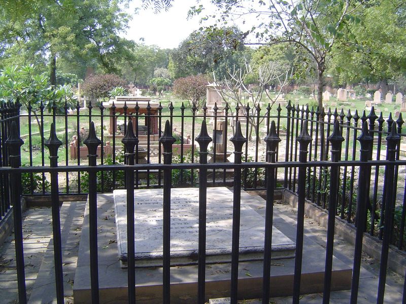 A wider view of the same cemetery, with an iron fence around its most famous occupant.
