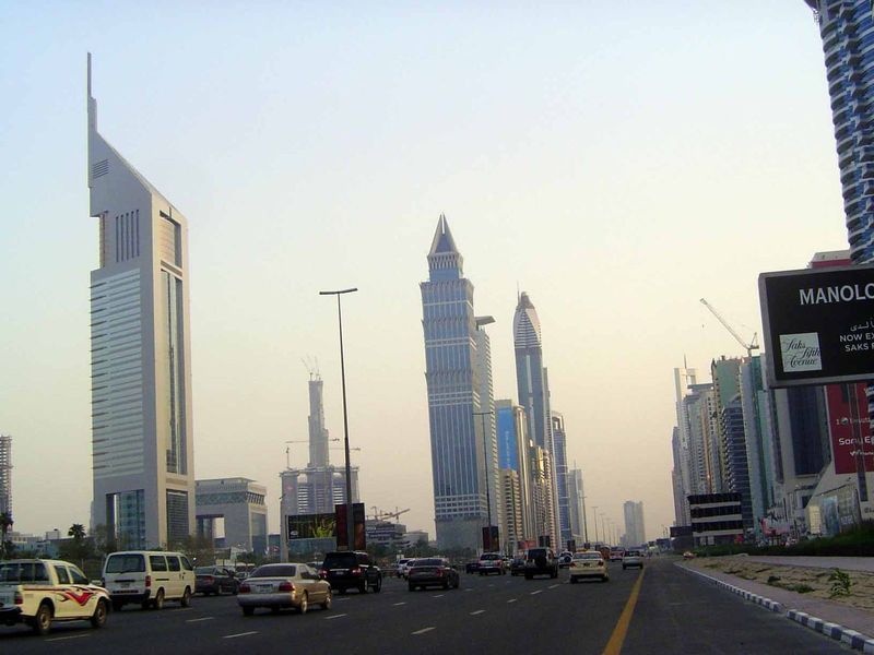 OK? We've pulled over and stopped. On the left is one of the two Emirates Towers, completed in 2000 and designed by Hazel W.S. Wong of NORR 