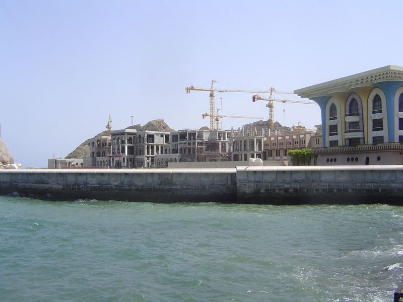 In the light of day, new government buildings go up next to the sultan's palace.