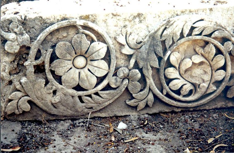 Floral details on a stone in the same storage yard.