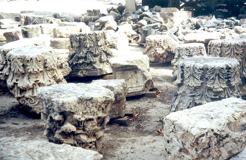 Assorted capitals scattered in a storage yard.