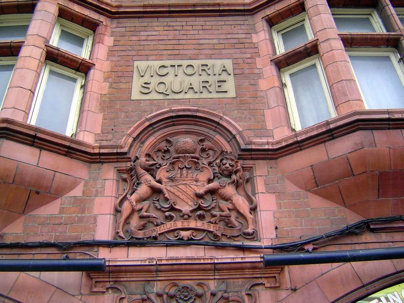 The original entrance, now blocked. The city's arms carry its no-nonsense motto, Concilio et Labore, "Counsel and Labor."