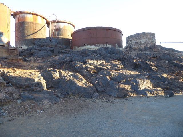 Water tanks near the headframe stand on the only surviving bit of the rock that Charlie Rasp saw and recognized as "gossan," a rock found ar