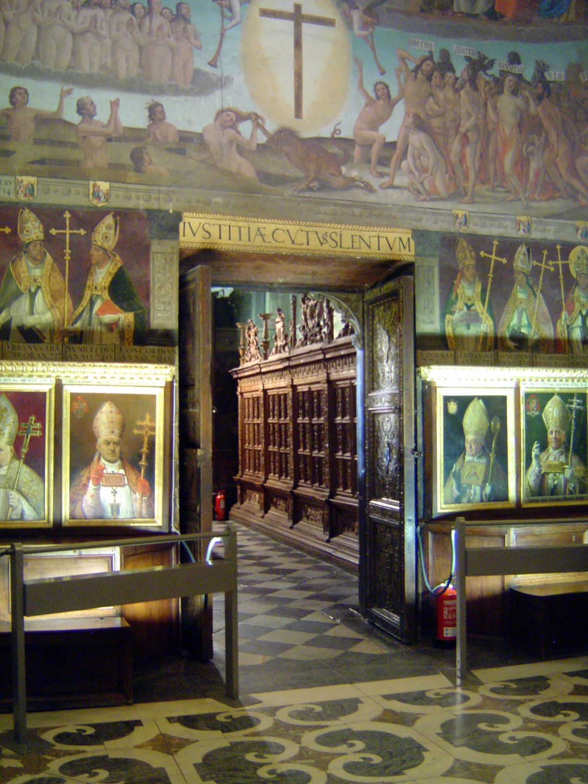 The Chapter House or meeting room is wrapped by portraits of Toledo's archbishops. Through the door is the panelled anteroom or antesala.