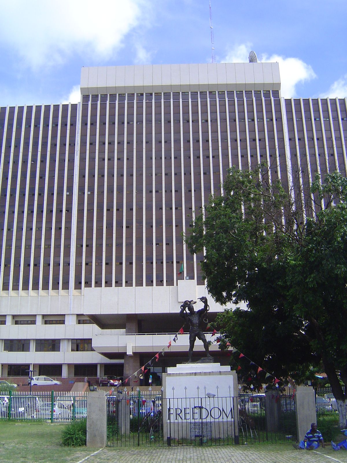 Facing the street is the Government Complex. In front of it is a monument unveiled in 1974 on the tenth anniversary of independence.