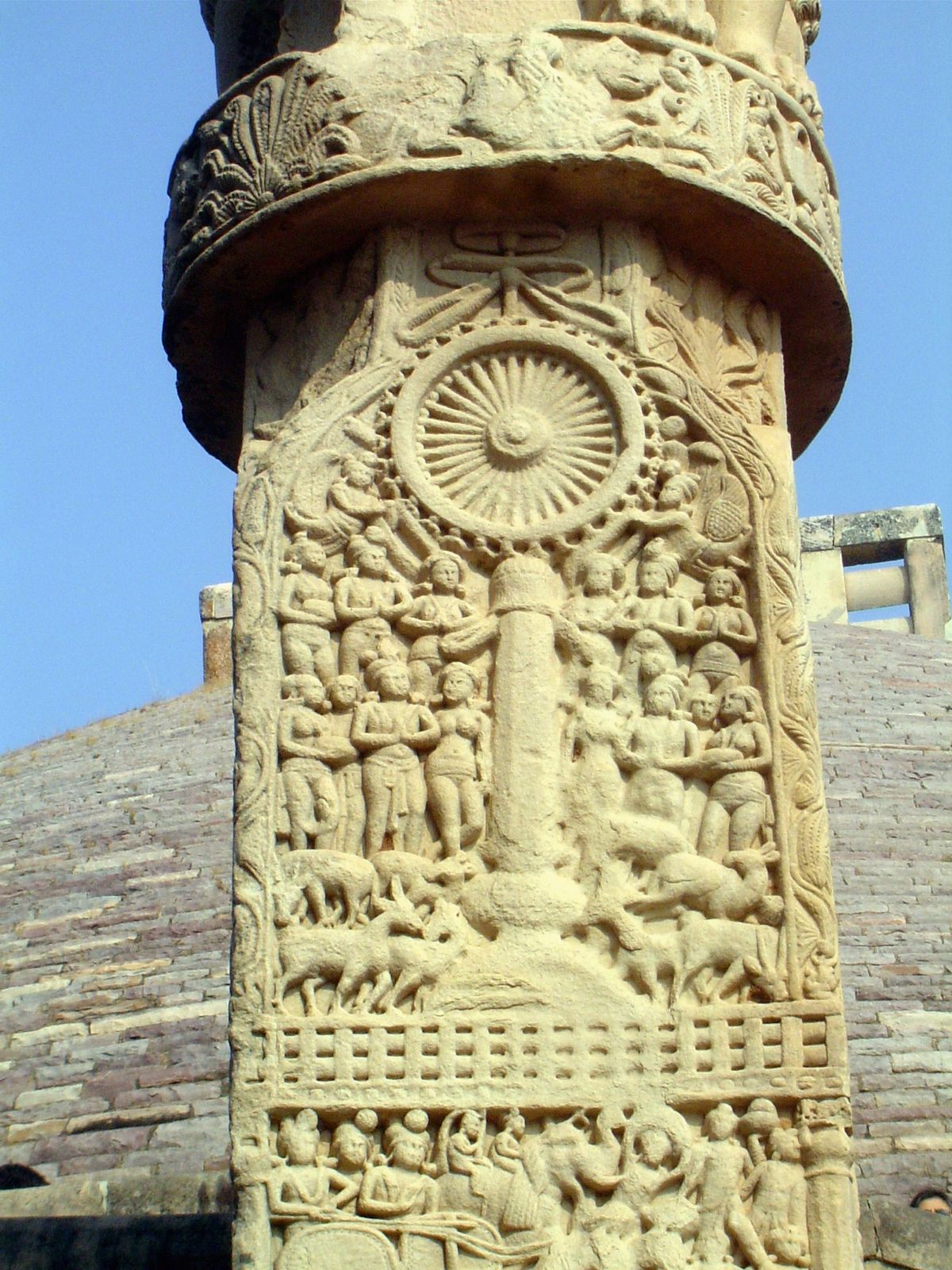 The front side of the west pillar of the south gate shows the Buddha's first sermon, preached at Benares to the four guardians of the world,