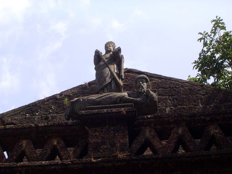 It shows a woman, sword in hand, standing over a man in native dress. Symbol of Portugal's rule?