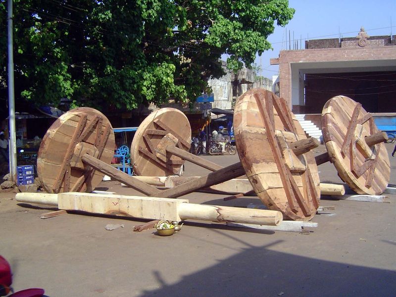 Outside the temple, wheels are built for a temple cart, or ratha.
