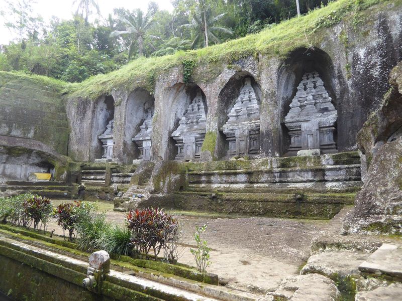 They're 11th century tombs in the form of temples. Cut into bedrock, they were dedicated to King Anak Wungsu of the Udayana dynasty and prob