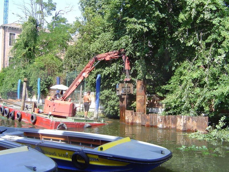 Meanwhile, there's work to be done keeping land and water separate. Here, a barge pulls up one of the temporary and interlocking steel piles