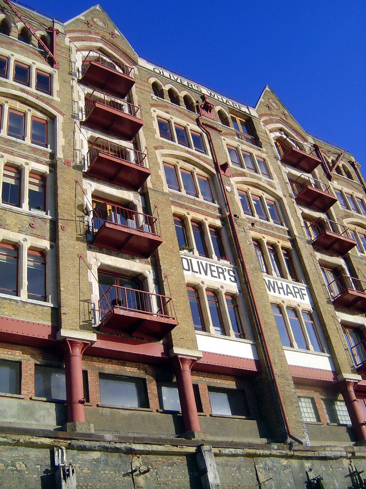 Oliver's Wharf was built in 1870 to handle tea but was converted in 1972 to flats. Cast-iron columns support a timber and brick building tri