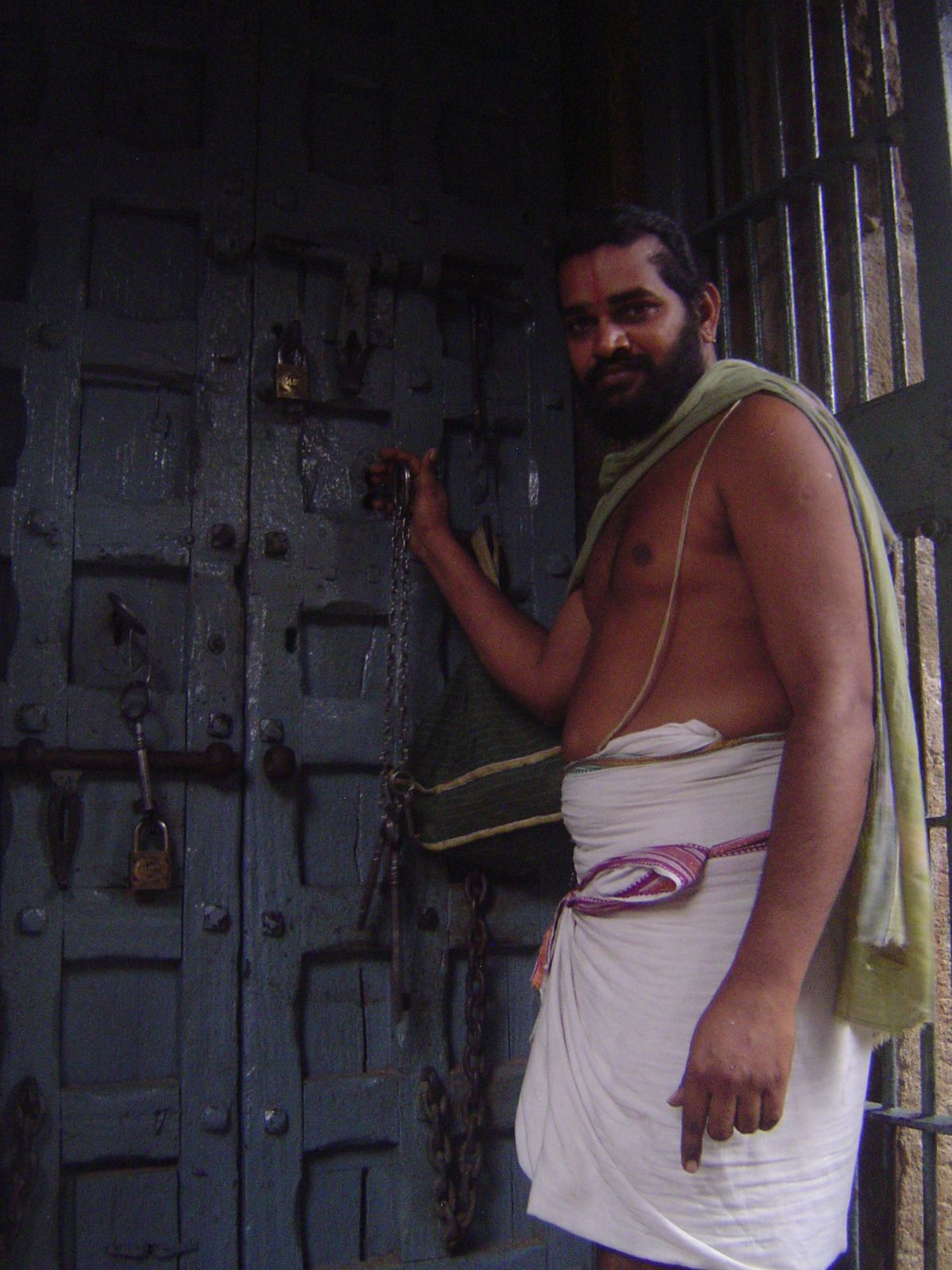 The priest unlocks the door to the shrine.