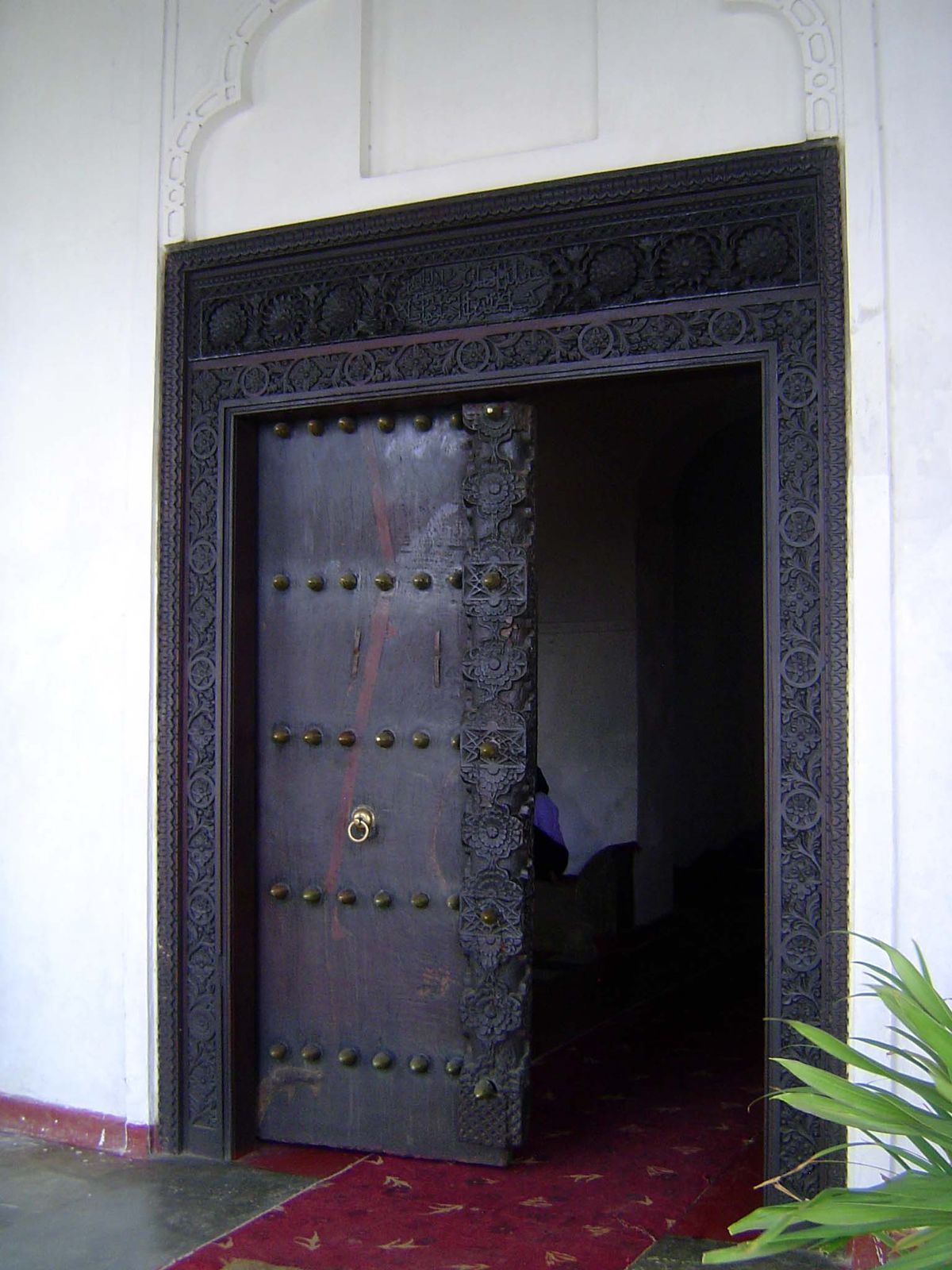 The door is Omani, with plain panels and carved but rectangular lintel.