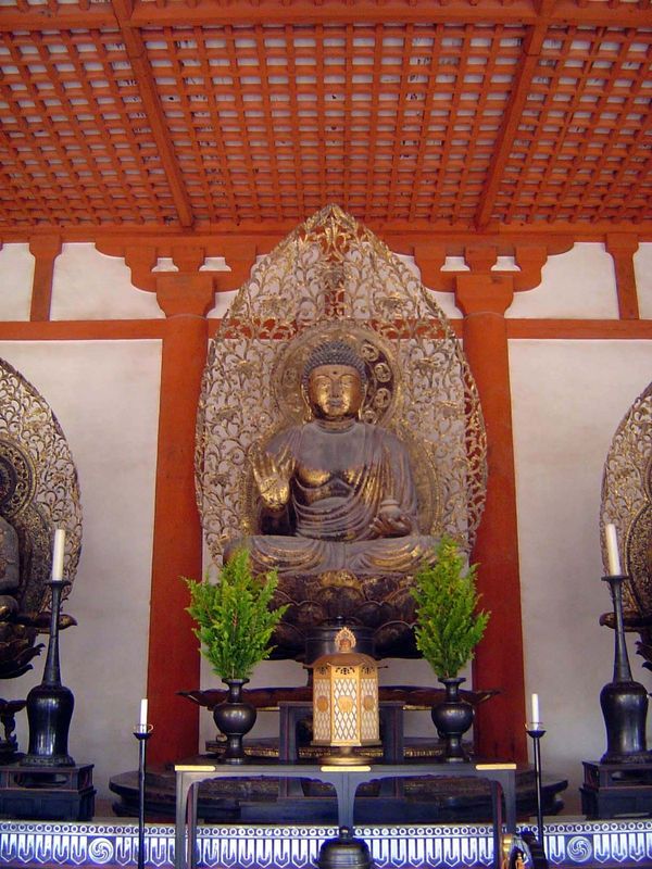 The figure is the Buddha Yakushi Sanskrit = Bhaishajyaguru, the "Healing Teacher," flanked here by attendants. Yakushi appears here because 