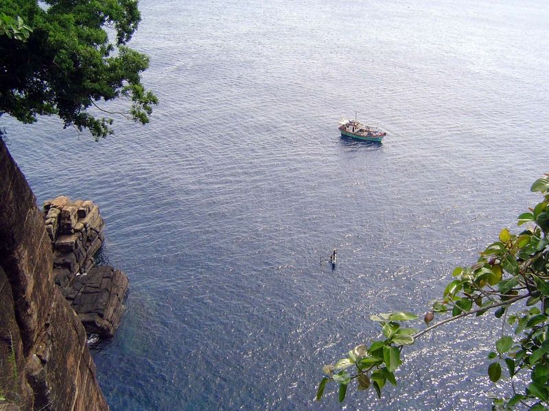 A fishing boat passes below.