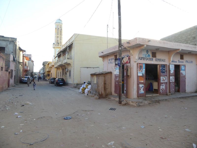A simpler market farther up the island, where the rent goes down. In the distance is the minaret of the Zawiya Tidiane or Tidjaniya sufi ass