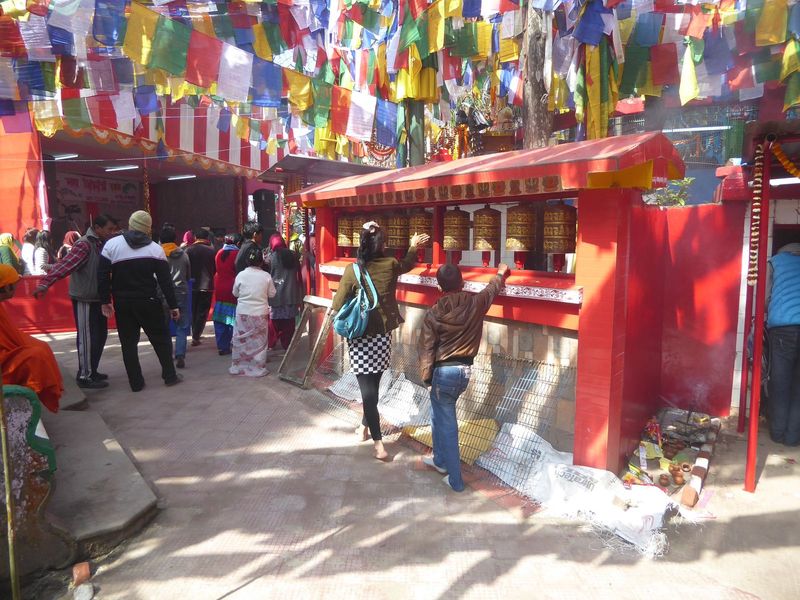 Next to the Shiva shrine, there are Buddhist prayer wheels.