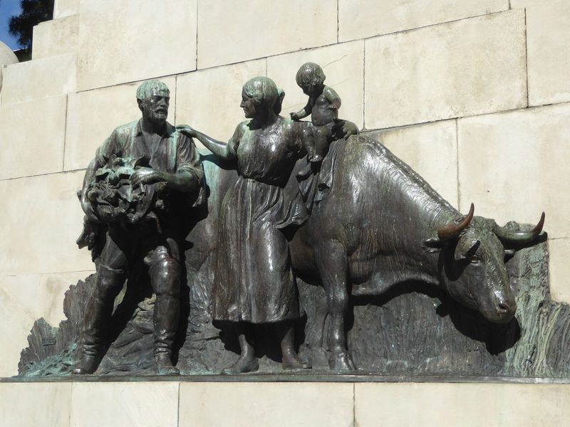 Grain production and beef remain very important, though I can't tell what the man in carrying. The cow seems to be thinking something like "