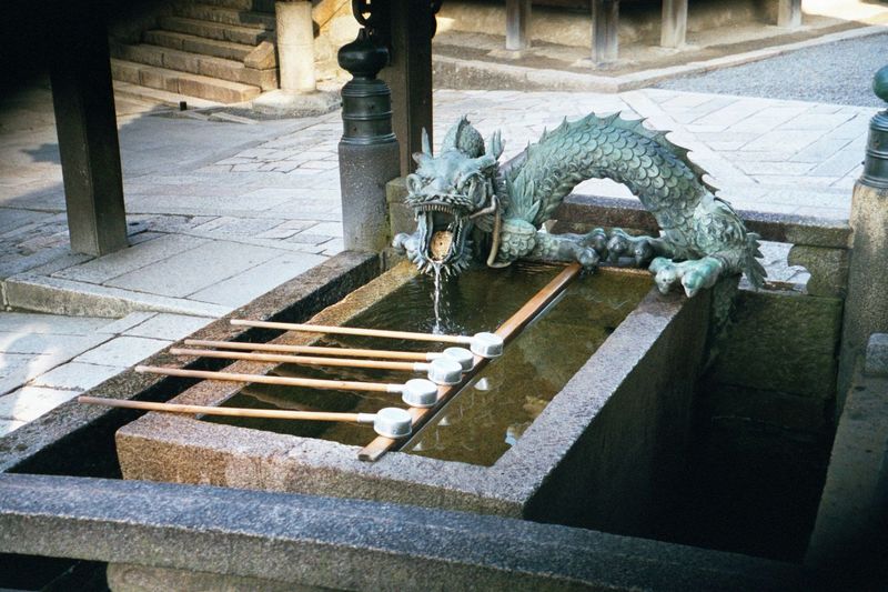 On the approach, a dragon fountain. The dippers are for public use.