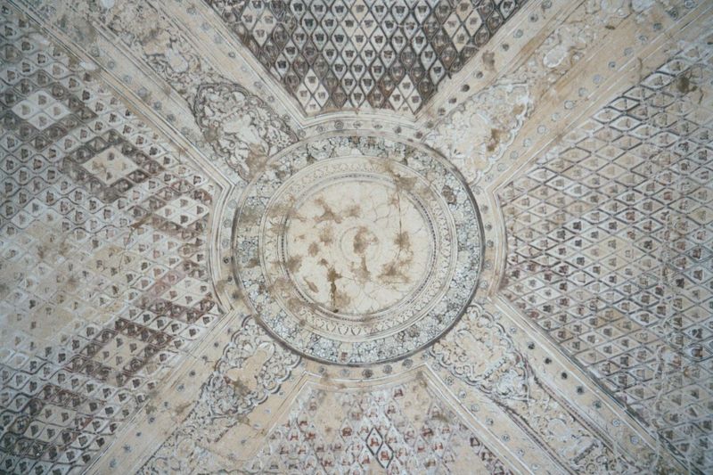 The ceiling vault is decorated with hundreds of Buddha images around the lotus pool of creation.