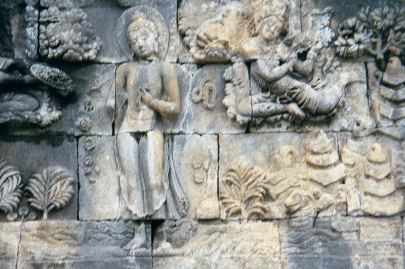 He bathes while gods throw flowers. In the lower right, two nagas or water spirits appear; they will give him a throne.