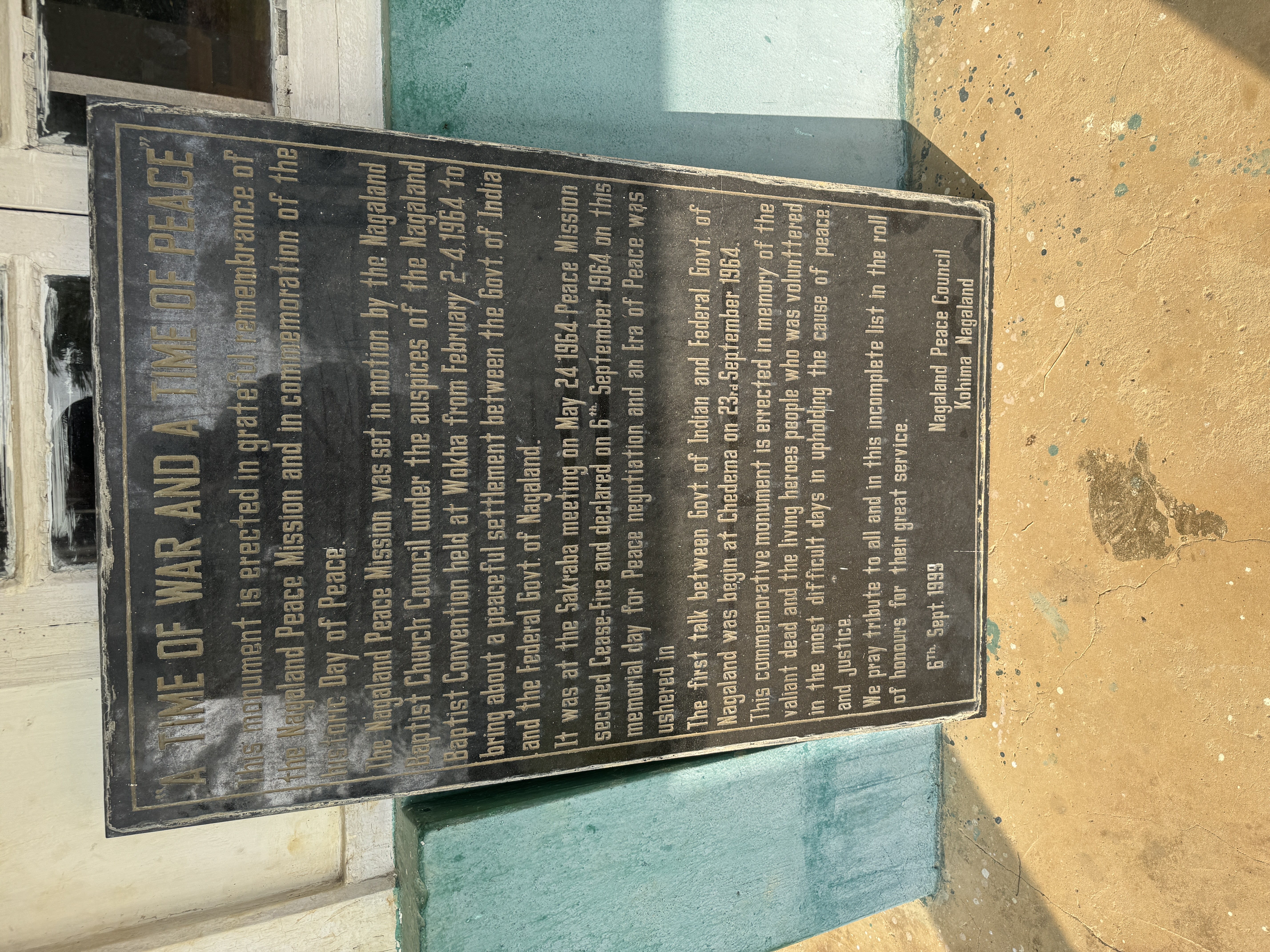 A later plaque leans against the building's wall and echoes Ecclesiastes.