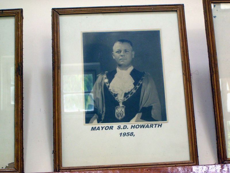 On a wall, a lineup of local dignitaries.
