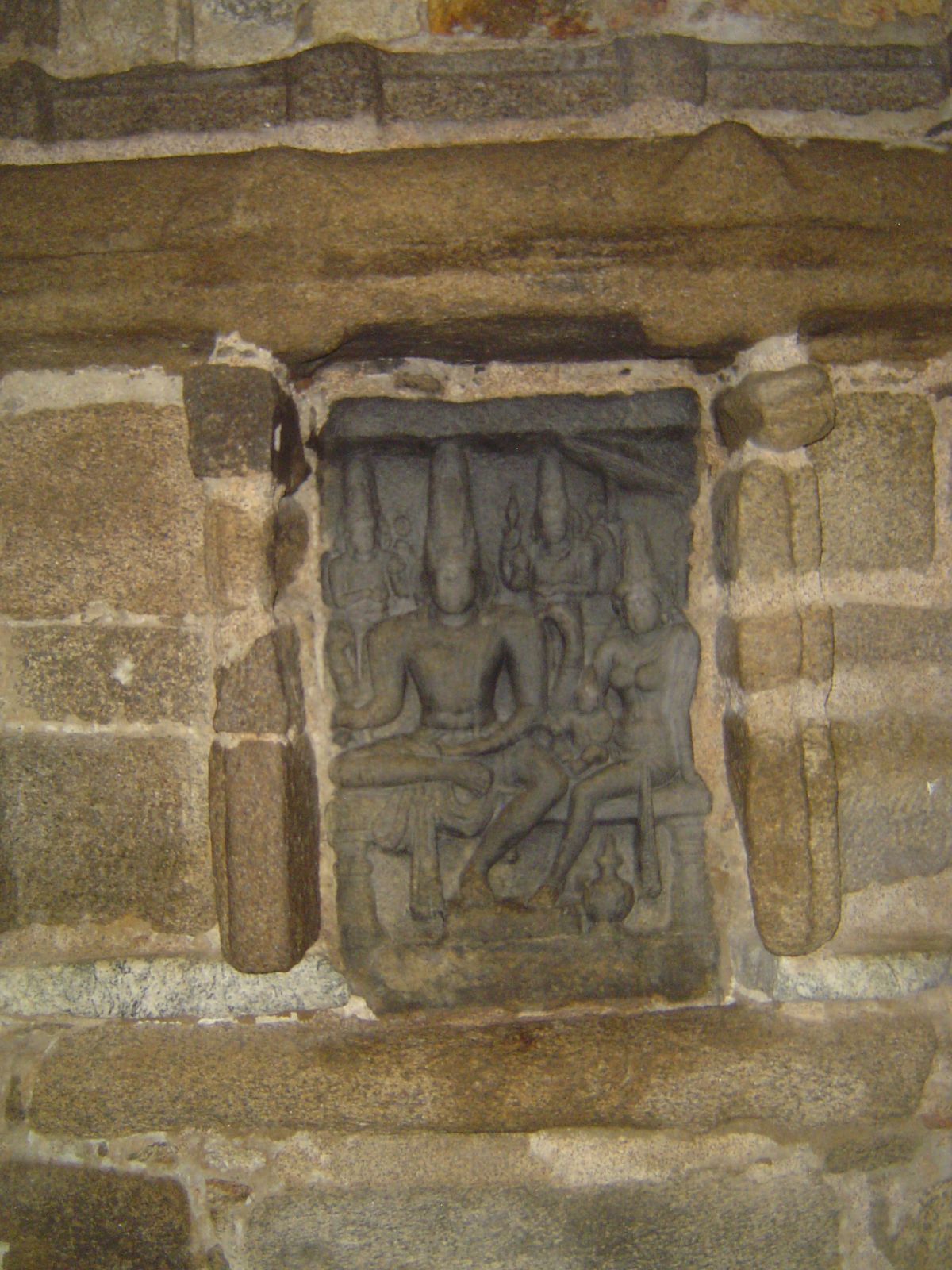Built into the back or west wall is a Somaskanda or family portrait of Shiva with wife and child. Such portraits originated with the Pallava