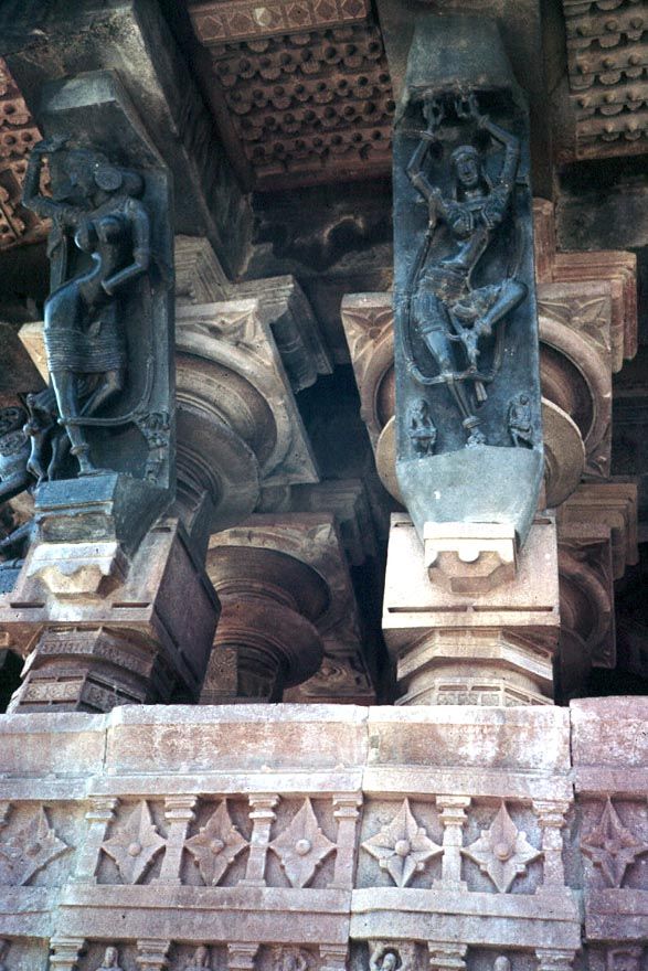 Carved figures on basalt brackets support the temple eaves.