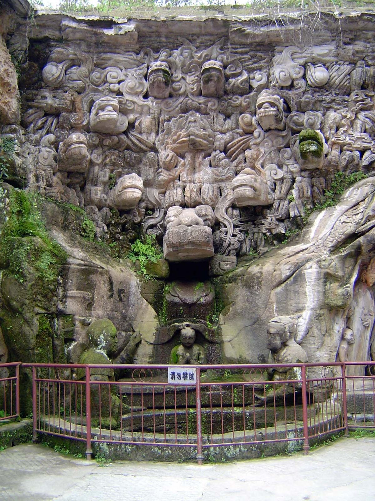 To the left of the giant Buddha and starting down the other side of the canyon, the young Sakyamuni Buddha bathes in a pool filled by water 