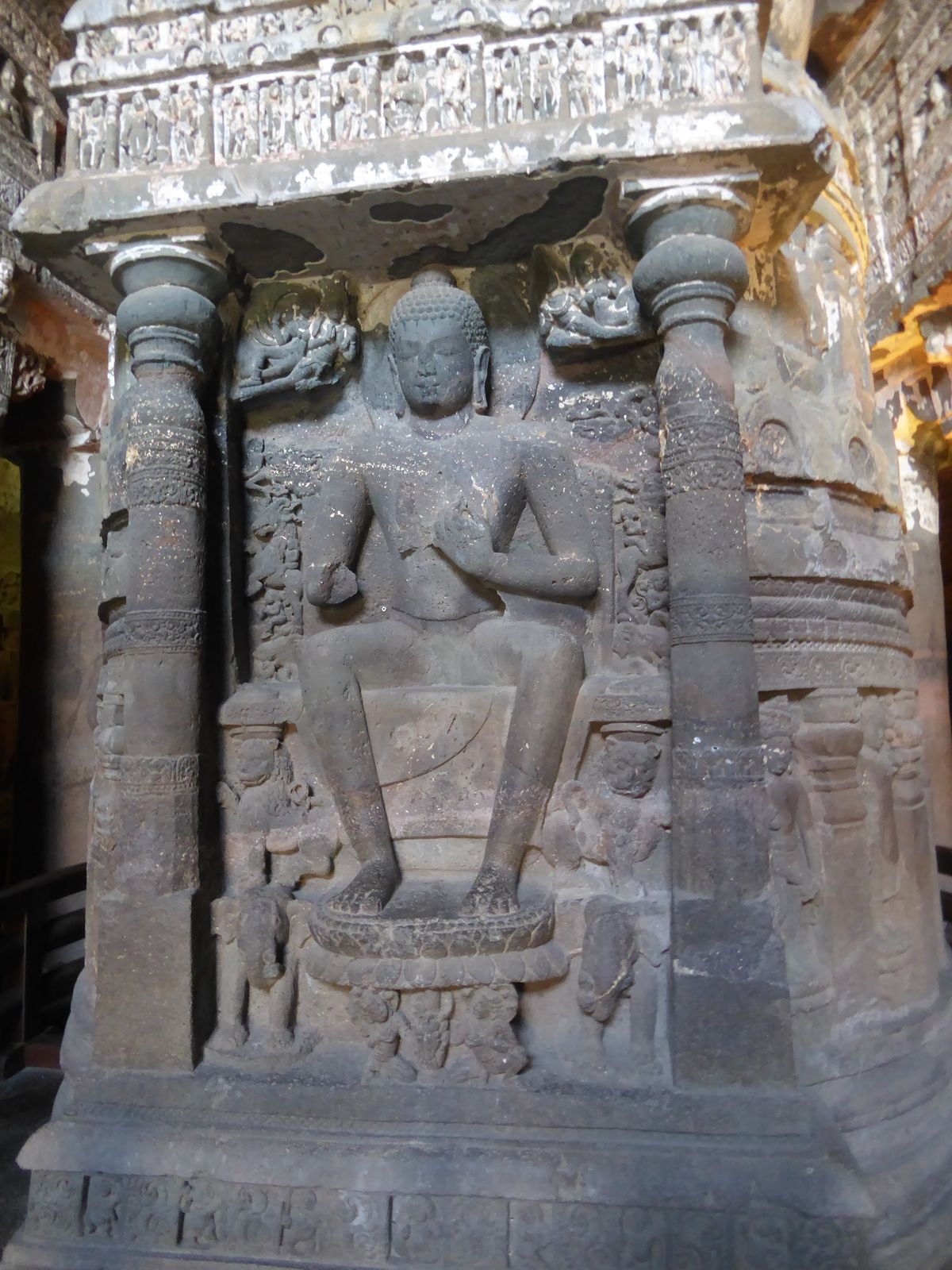 The figures that usually flank the Buddha have, for lack of space, been moved onto the drum.