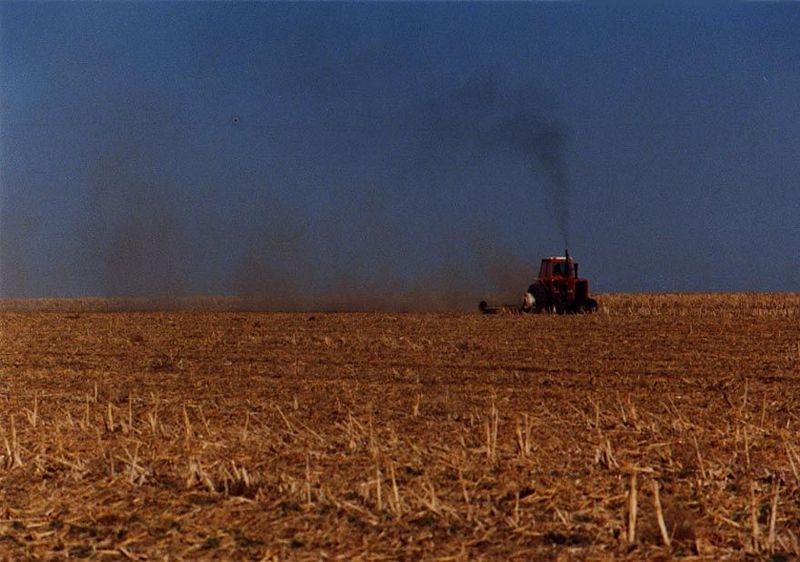 Tractor at work, dust on the move.