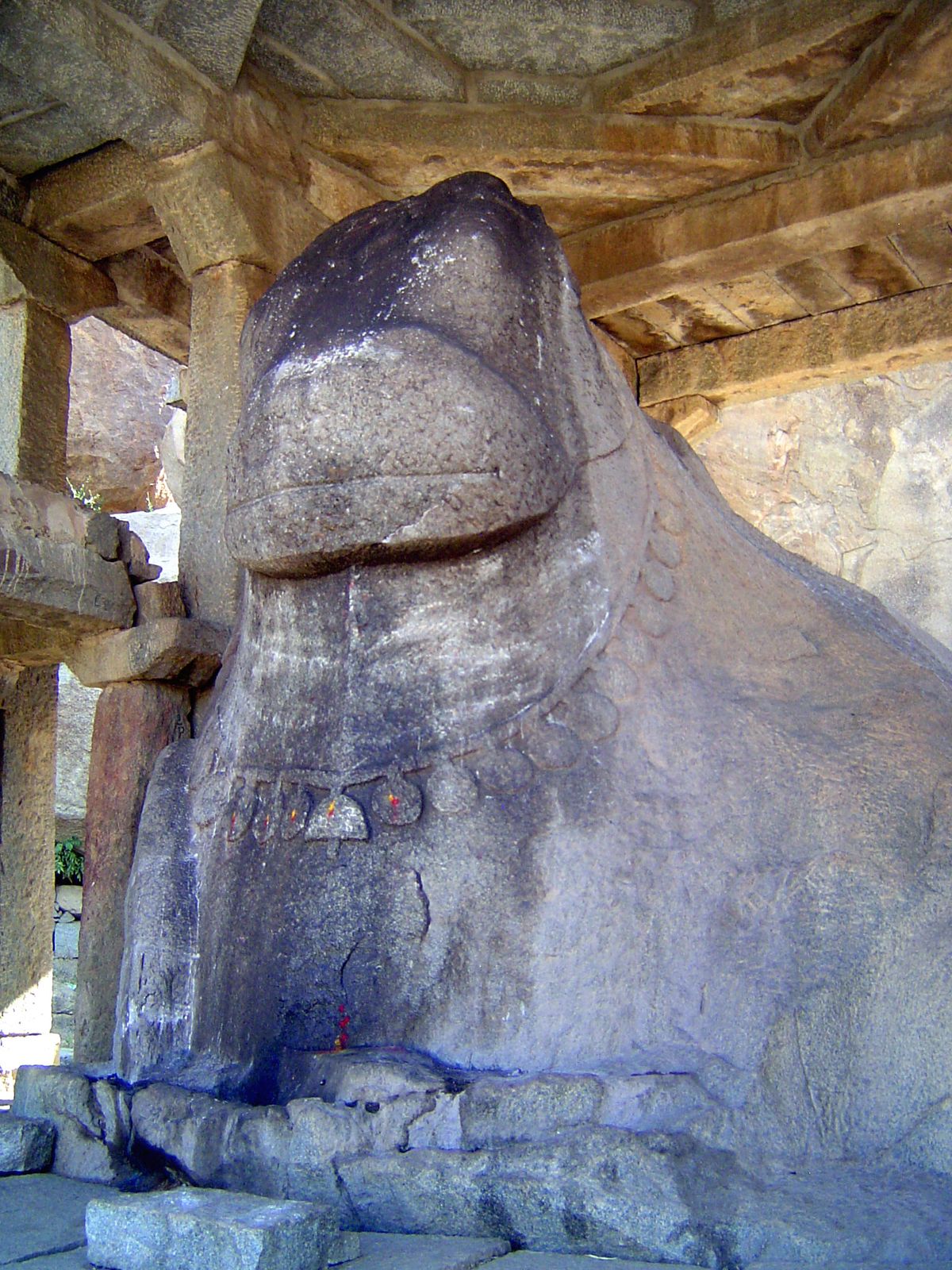 The image is crude but carved from a boulder. There are several other monoliths nearby.