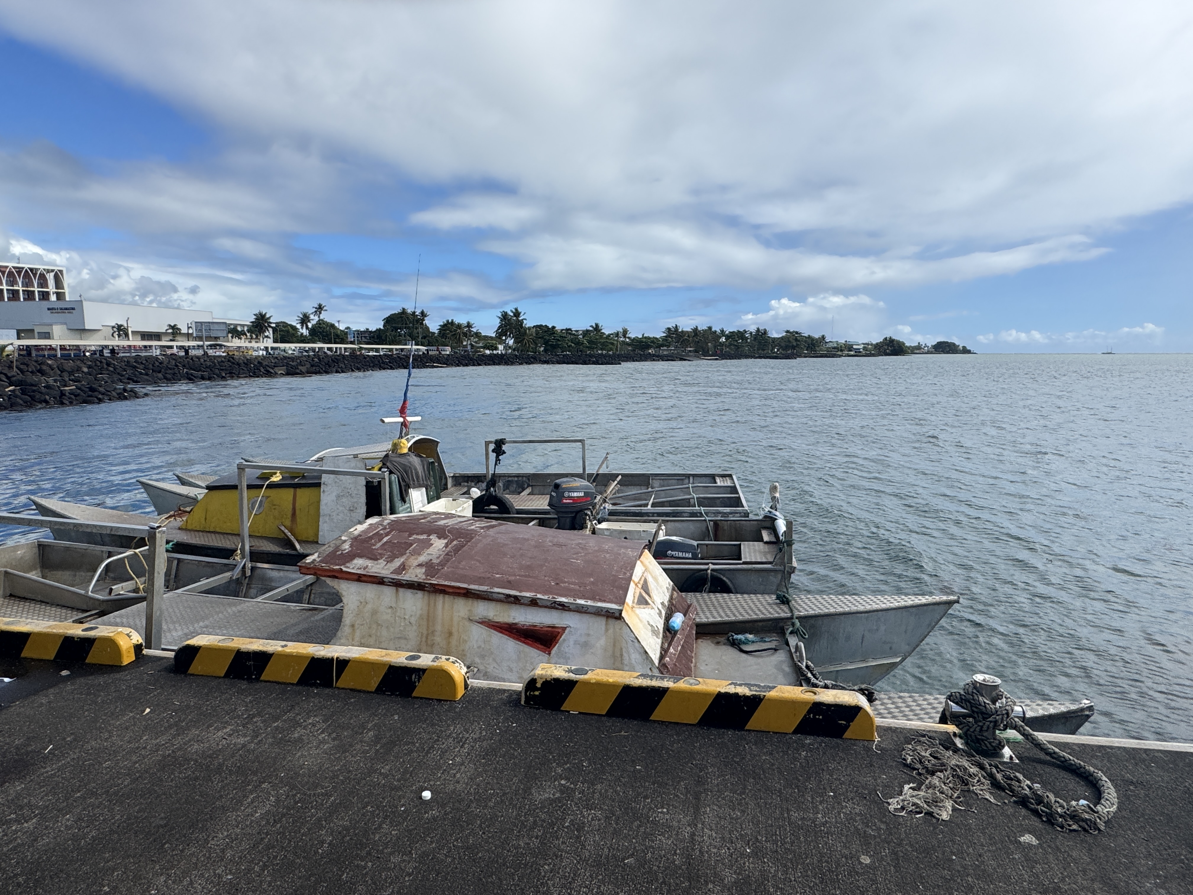 The  Mulinu'u Peninsula, with the monuments and tombs shown earlier, is in the distance.  See the faint line of buses on the waterfront?