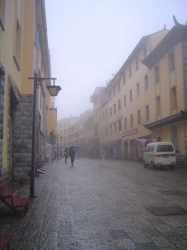 Here's Xinjie, the old county seat, uphill and on the same elevation as the Hani villages. It's ghostly not only because of the fog but beca