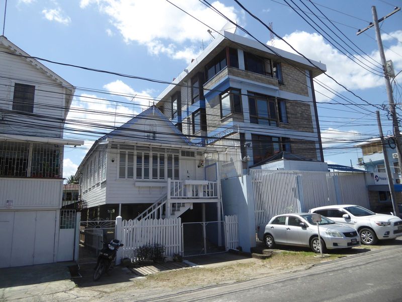 A house on stilts survives next to the offices of the Peace Corps, where gate guards, asked about the number of volunteers in the country, s