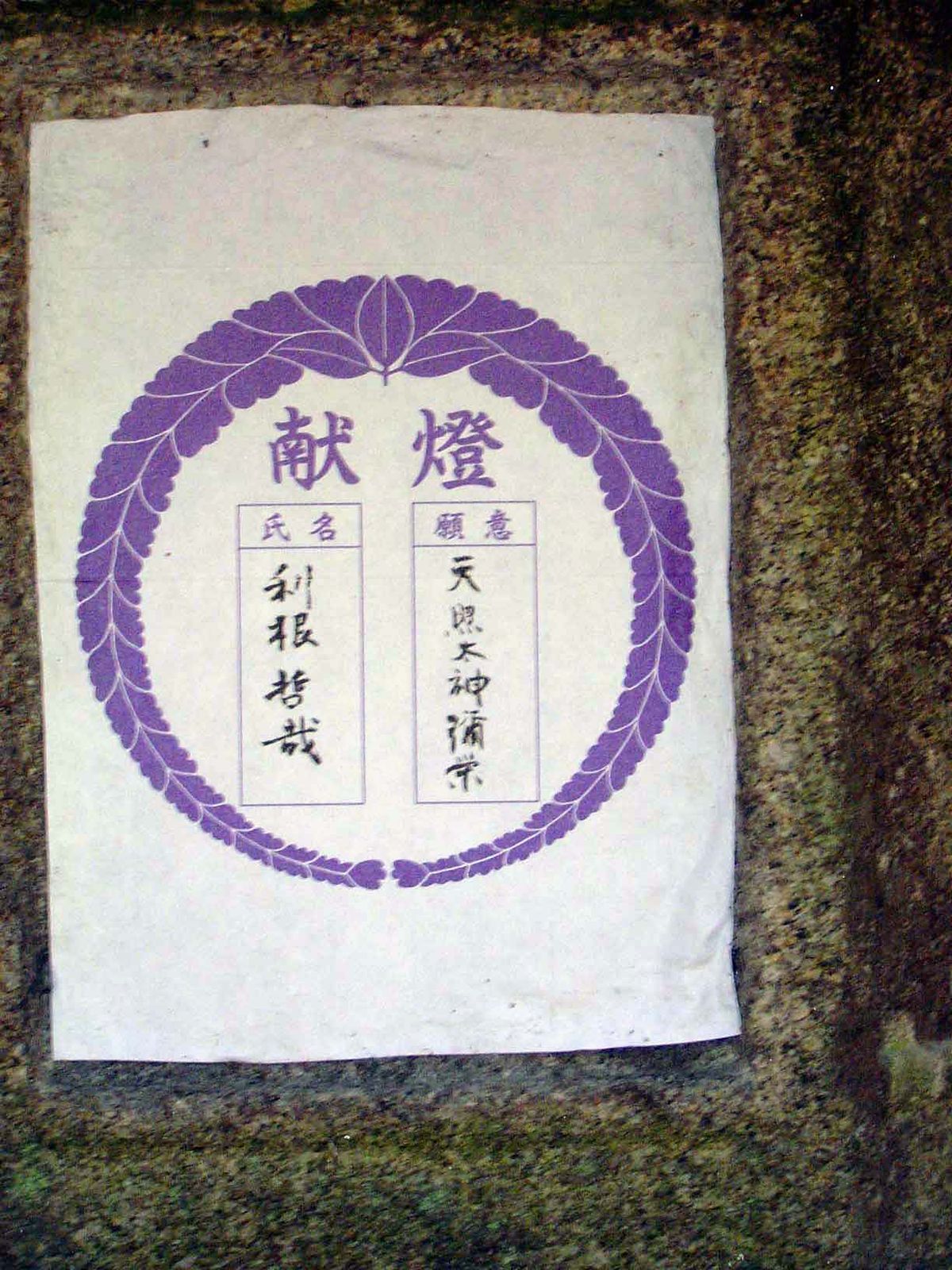 Many of the lanterns carry paper notices mentioning the person who paid for the most recent candle.