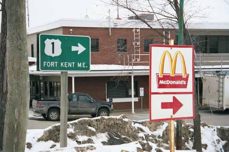 A few miles north, at Clair, New Brunswick, the green sign points to the international bridge crossing to Fort Kent. The McDonald's sign poi