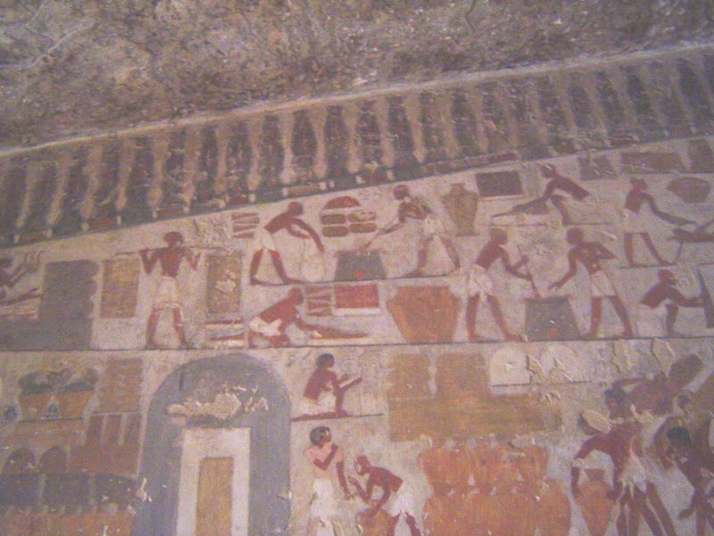 Higher on the same wall, there's a portrayal of the storerooms of the Temple of Amun at Karnak. At the lower left, goods are piled before th