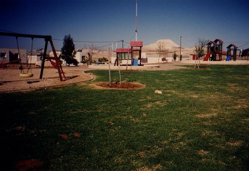 A playground at Tekoa. In the background rises Herodion, atop whose modified slope Herod built a palace where he supposedly is buried. The f