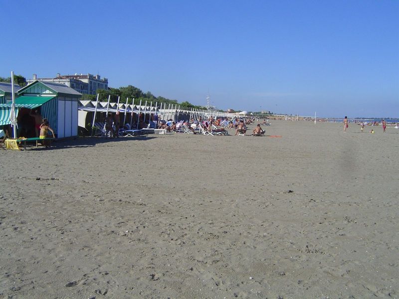 Here's another view, with the Hotel Des Bains in the background. Mann wrote, "a long row of capanne ran down the beach, with platforms, wher