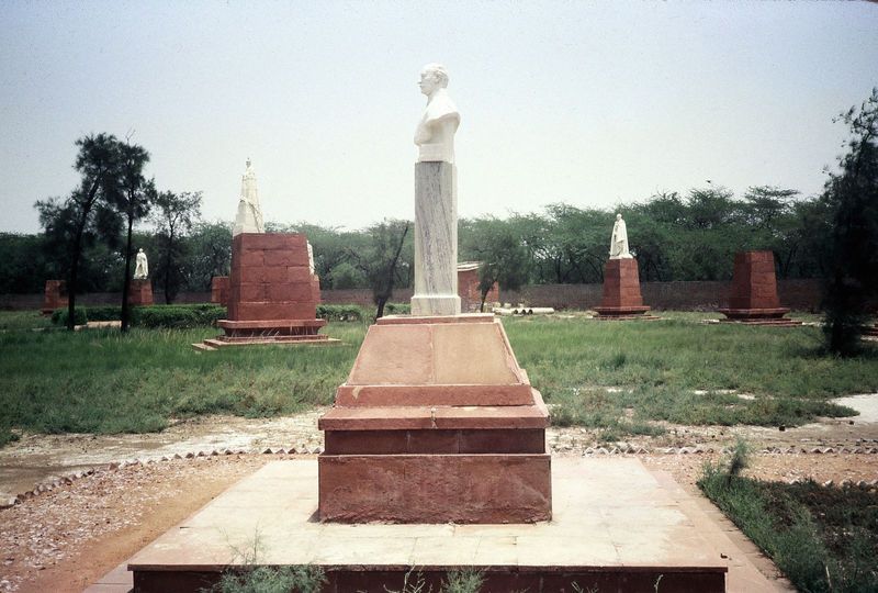 George stands surrounded by acolytes, or in some cases merely their plinths.