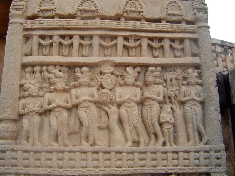 Here's the base of the front side of the east pillar of the north gate, showing the miracle of Sravasti. The skeptical court of Prasenajit w